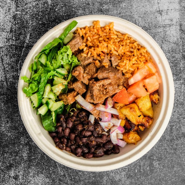 Suya Outpost bowl with jollof rice, beef suya, black beans, plantains, lettuce, and tomatoes.